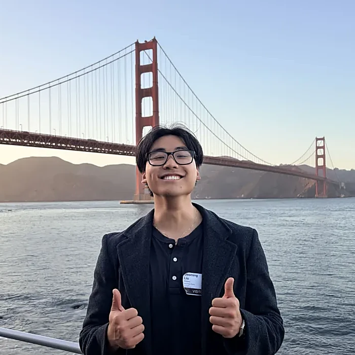 Andrew at the Golden Gate Bridge, smiling with two thumbs up